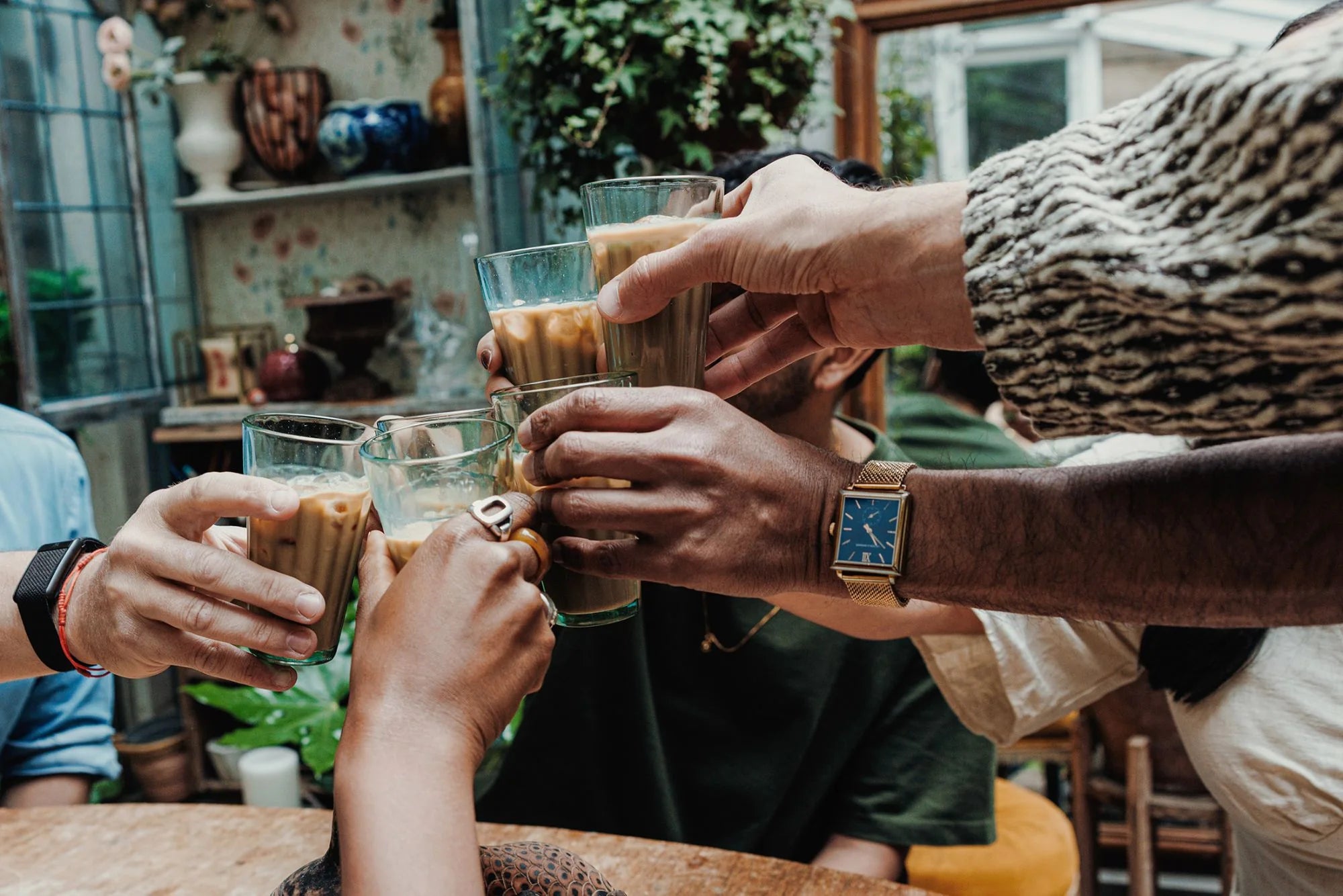 Friends raising glasses of iced chai together