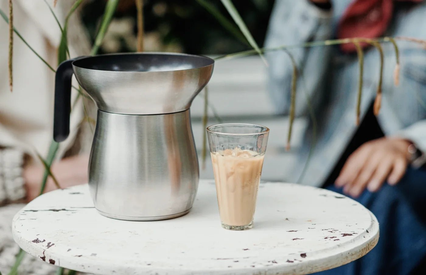 The Loka Chai Maker beside a glass of iced chai